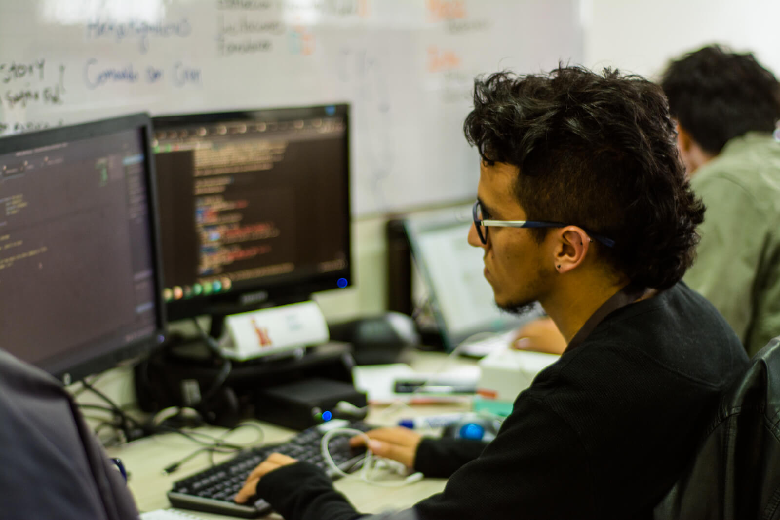 hombre con gafas trabajando frente a computador en oficina de infometrika